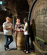 3 Personen am alten Weinfass beim Weinverkosten
