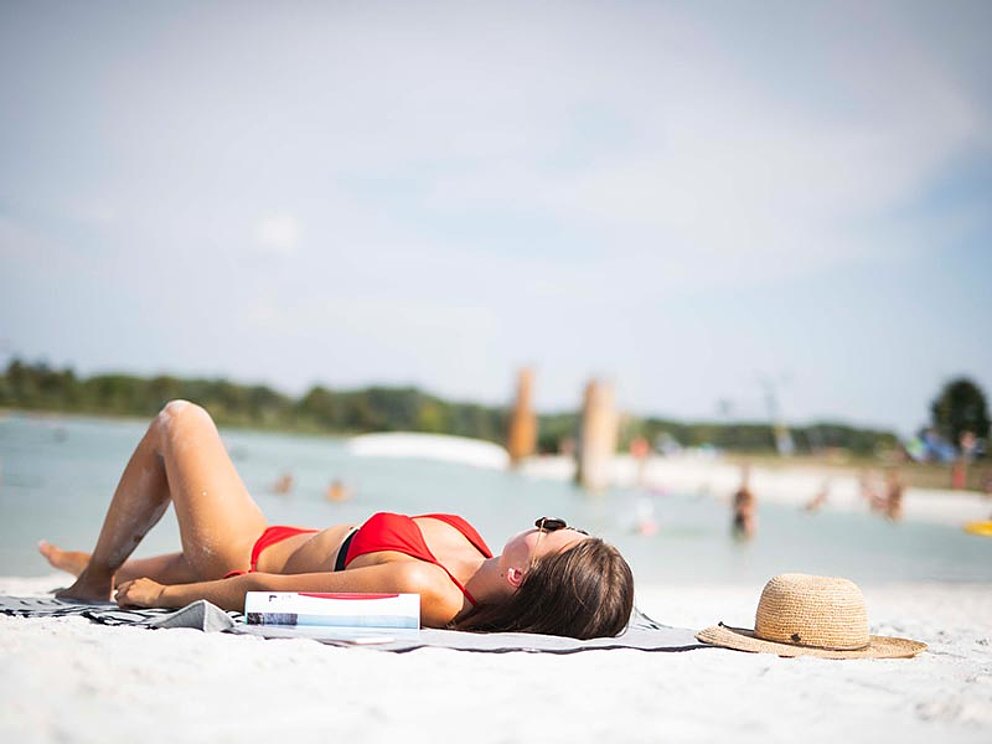 Eine Dame im roten Bikini beim Sonnenbad in Feldkirchen